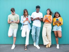 a group of people looking at their cellphones in school