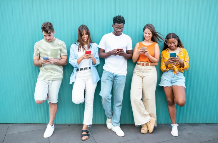 a group of people looking at their cellphones in school