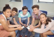 a group of kids sitting in a circle holding smartphones